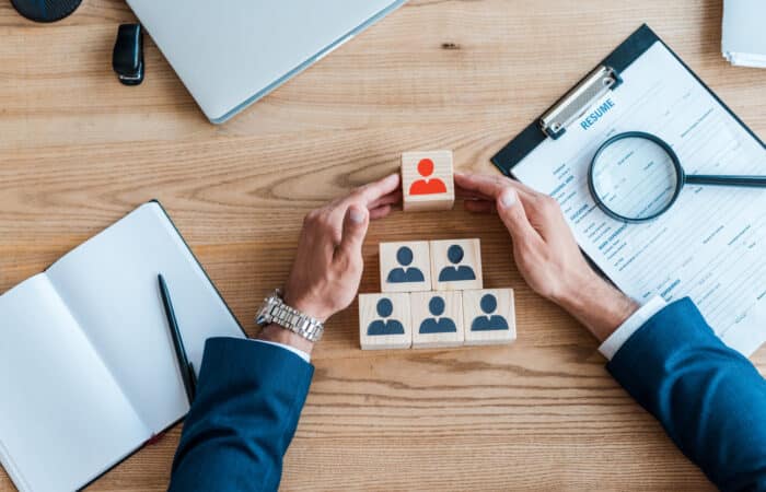 top view of recruiter near wooden cubes and clipboard on table